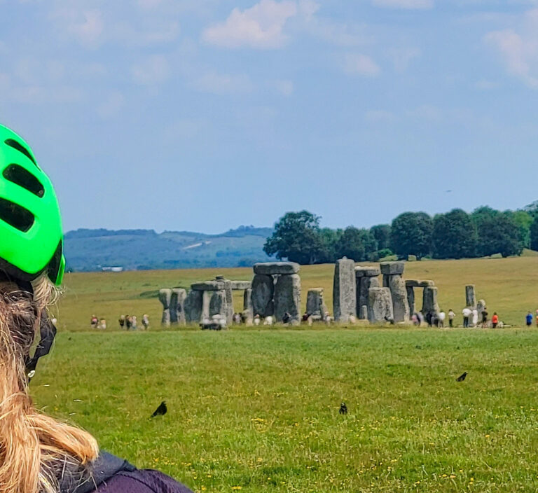 Cyclist on a guided tour looking towards Stonehenge, Wiltshire